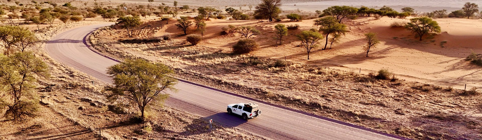 bushbundu-car-rental-windhoek-namibia-desert-image-with-trees-and-clouds-reservation-page-cover-image