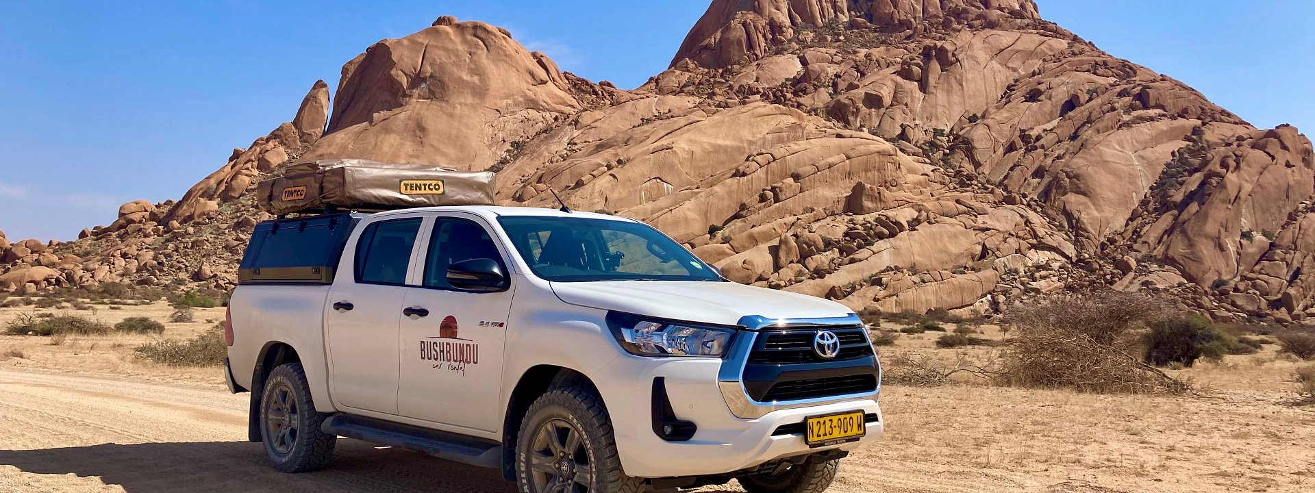 bushbundu-car-rental-windhoek-namibia-home-page-image-of-fully-equipped-with-camping-equipment-4x4-toyota-hilux-in-the-desert-front-view
