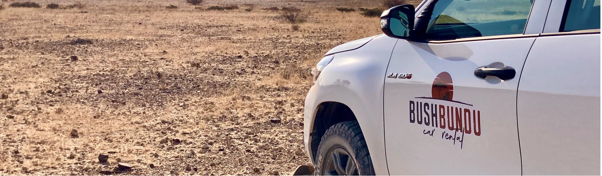 bushbundu-car-rental-windhoek-namibia-image-of-toyota-hilux-in-the-desert-with-bushbundu-logo-fleet-page-cover-image