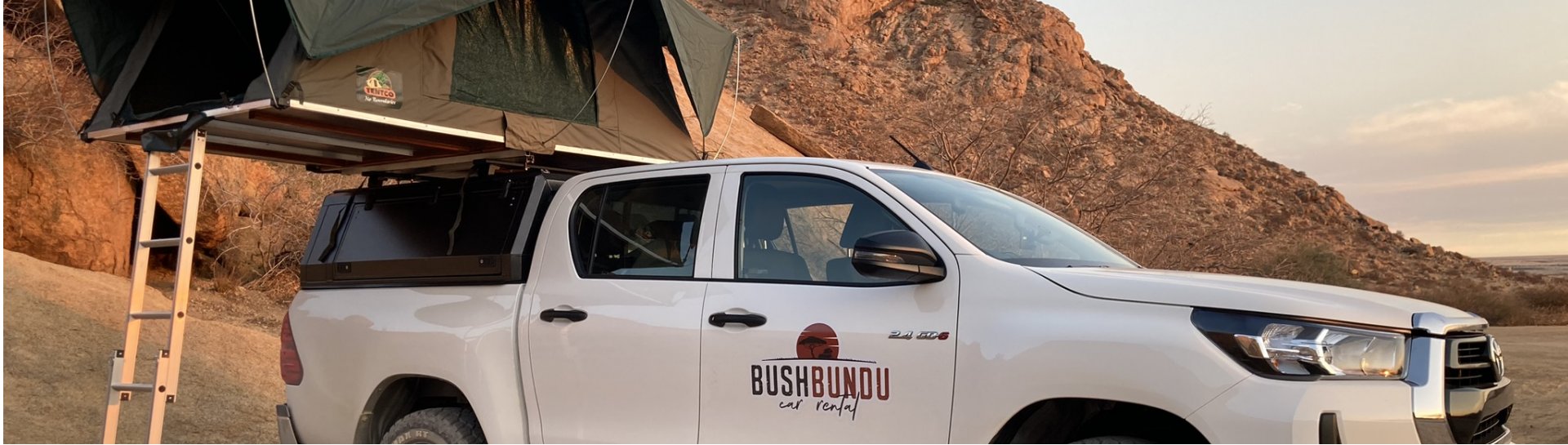 bushbundu-car-rental-windhoek-namibia-side-image-of-toyota-hilux-with-pitched-tent-on-the-roof-camping-page-cover-image