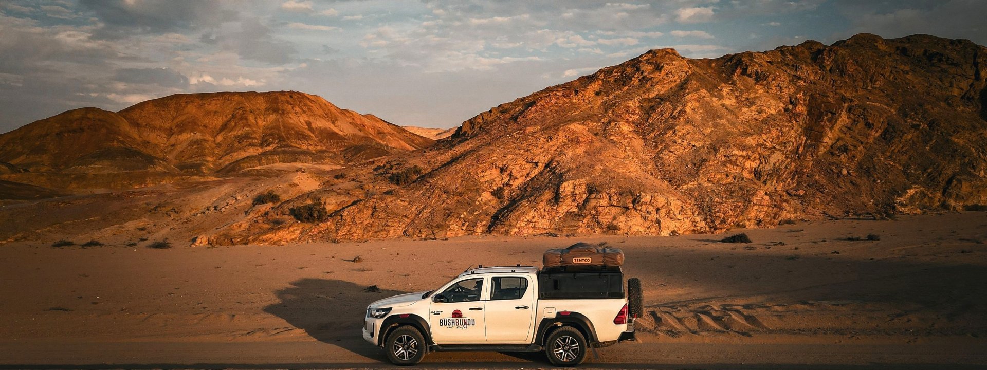 bushbundu-car-rental-windhoek-namibia-home-page-image-of-fully-equipped-with-camping-equipment-4x4-toyota-hilux-in-the-desert-front-view